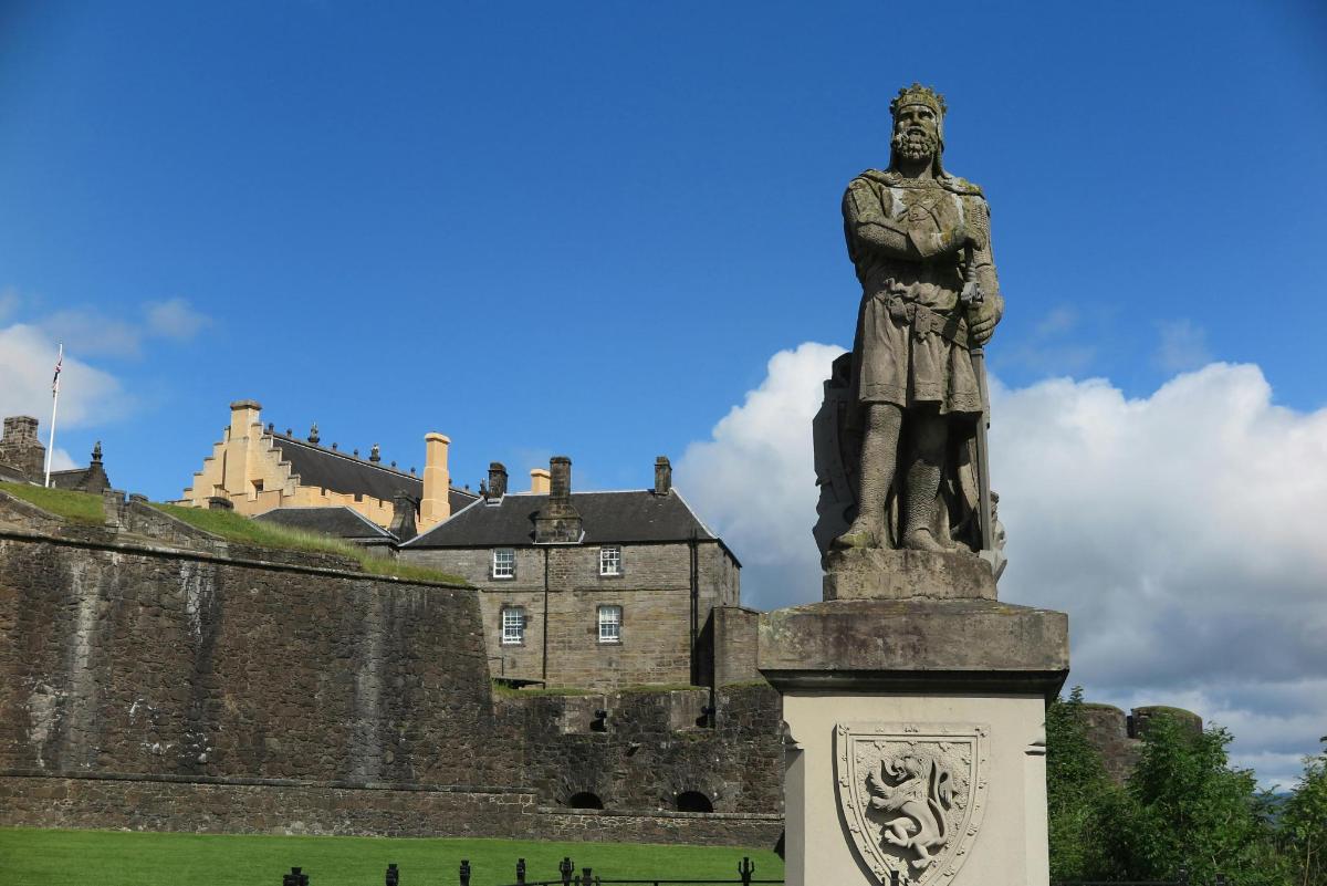 una statua di un uomo davanti a un castello