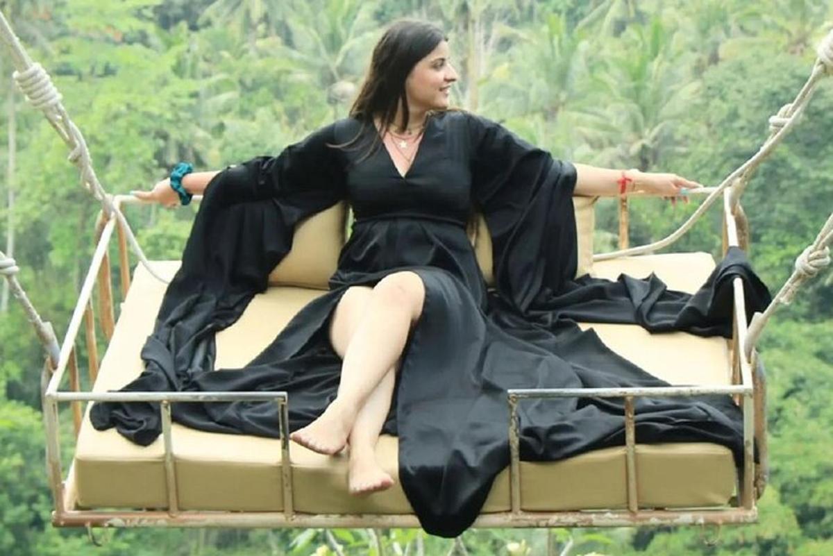 a woman in a dress sitting on a swing