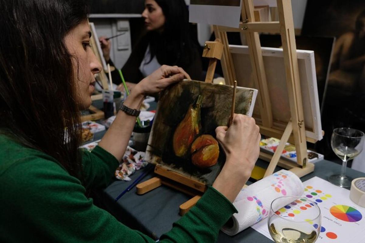 žena sedící u stolu a dívající se na obraz