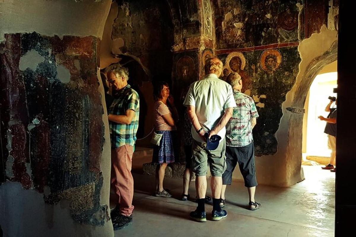 група людей, що стоять у кімнаті з картинами на стіні