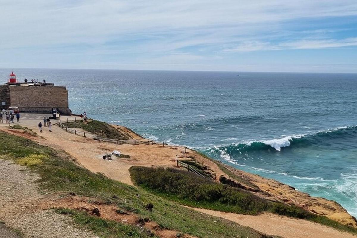 un gruppo di persone che camminano su una spiaggia vicino all'oceano