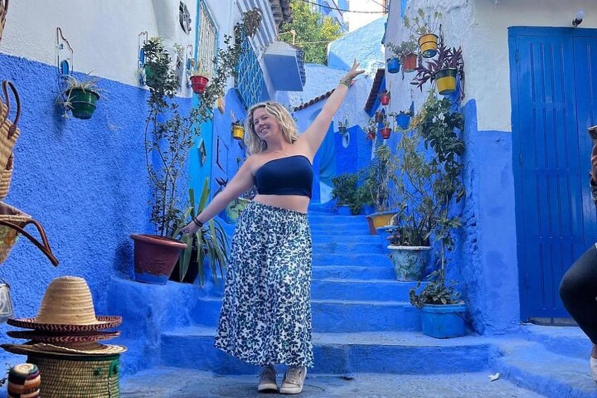 a woman is standing in front of a blue building