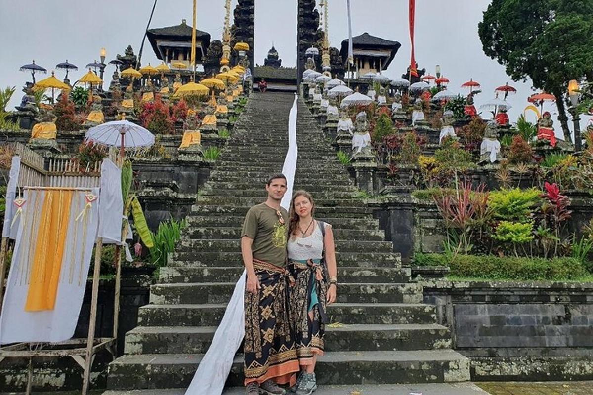 un uomo e una donna in piedi sulle scale di un tempio