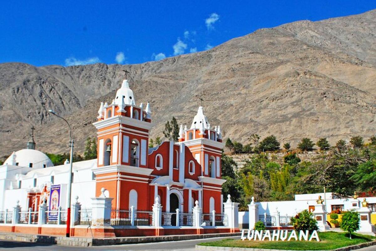 Un edificio rojo y blanco frente a una montaña.