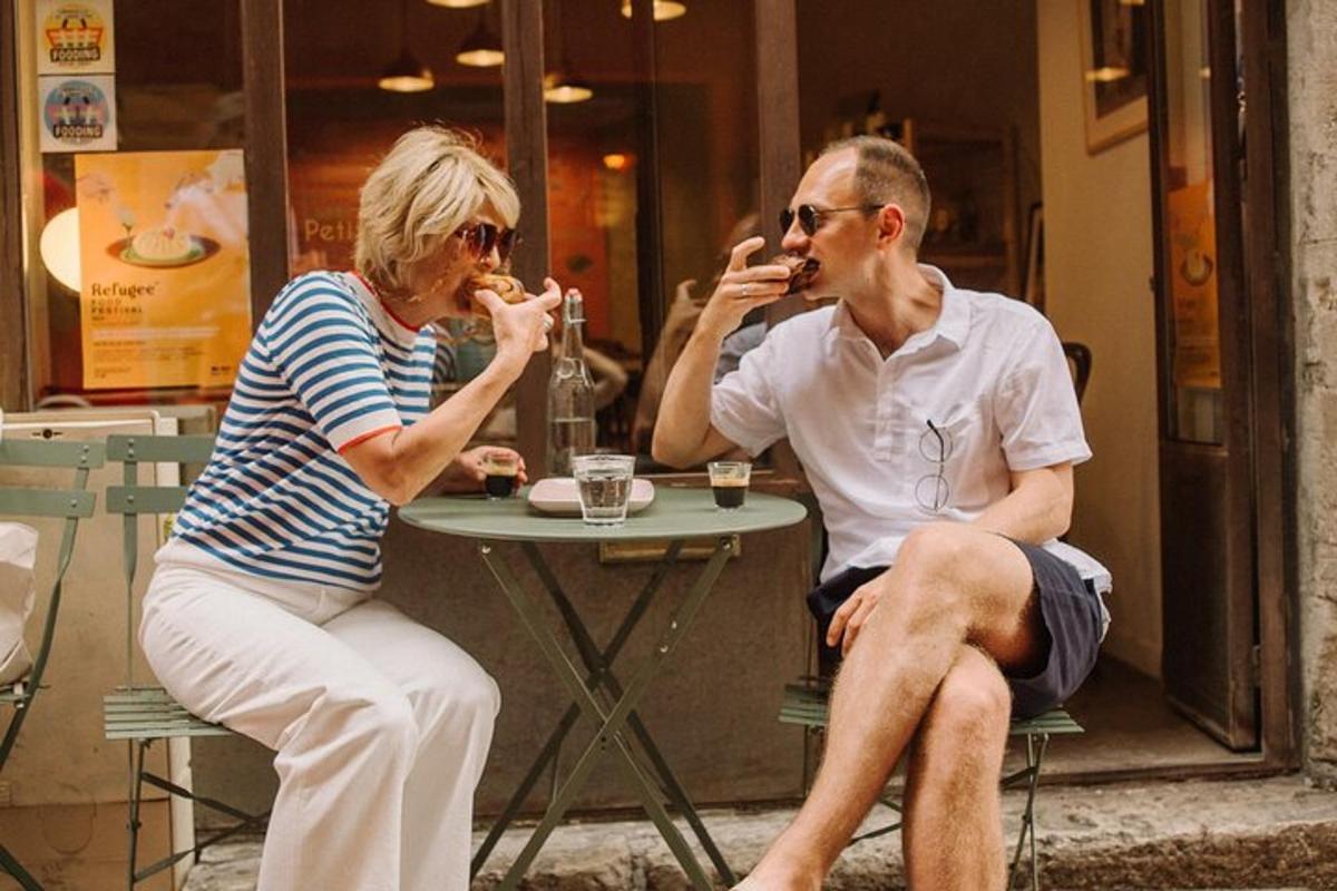 vīrietis un sieviete sēž pie galda un ēd