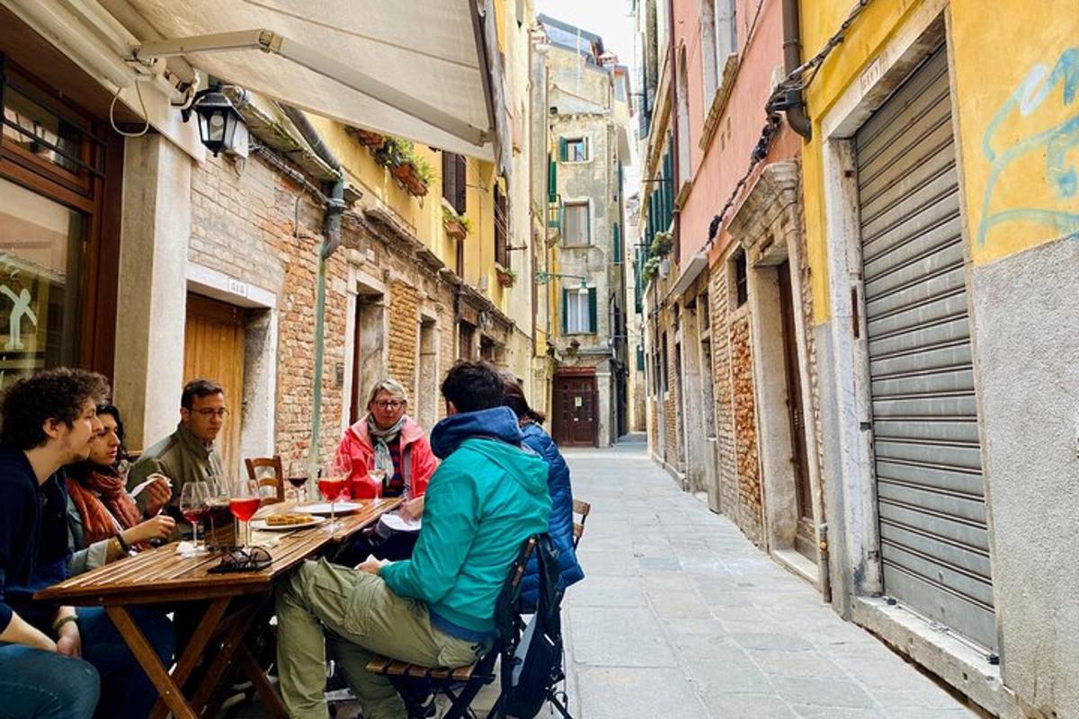 a group of people sitting at a table in an alley