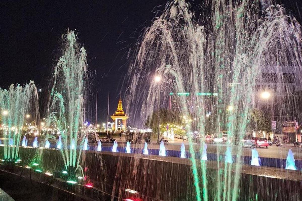 a group of water fountains in a city at night