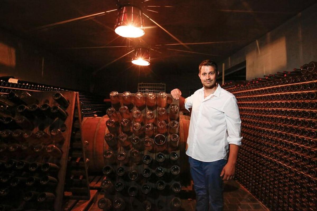 a man is standing in a wine cellar