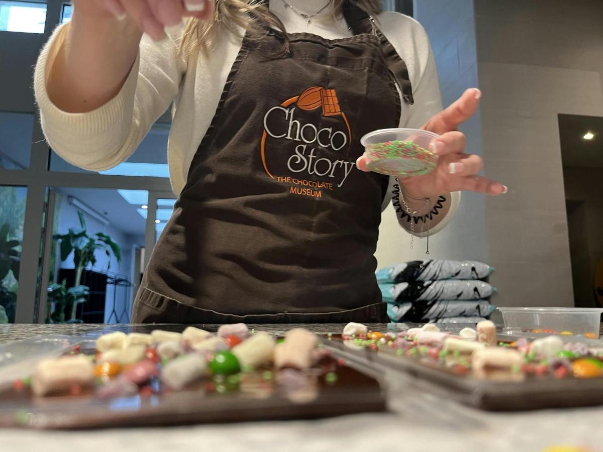 a woman in an apron holding a bowl of food