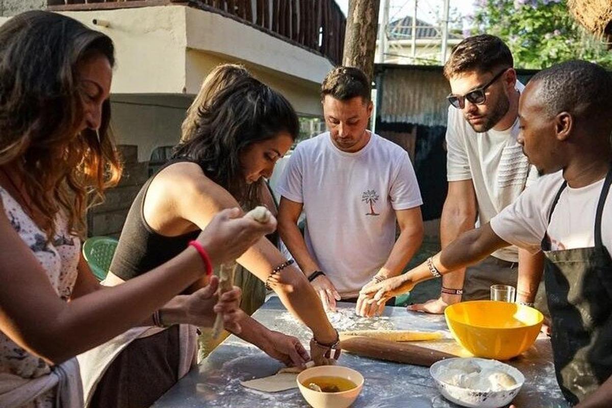 a group of people standing around a table preparing food