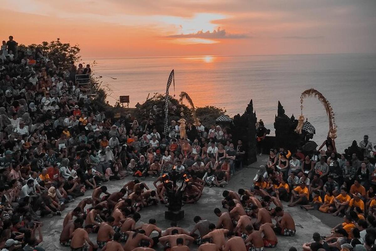 una grande folla di persone che guardano uno spettacolo al tramonto