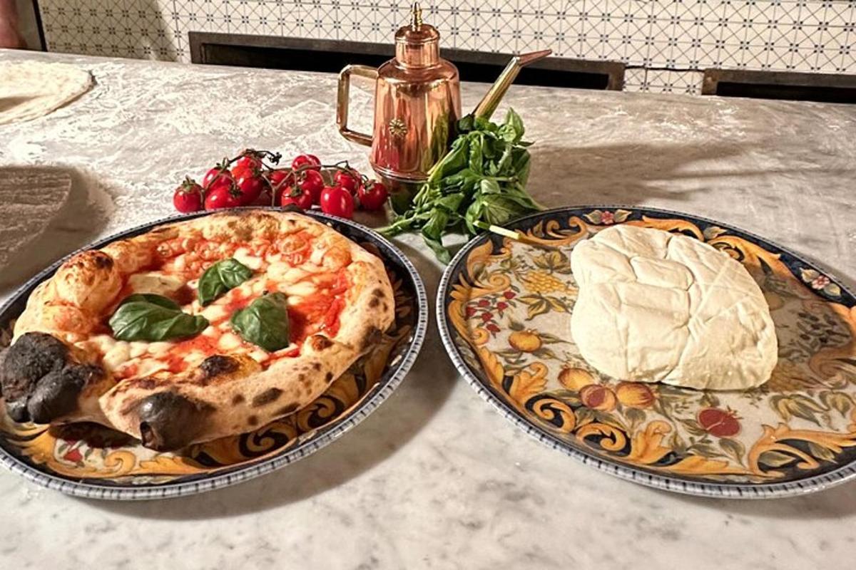 two plates of pizza and bread on a table