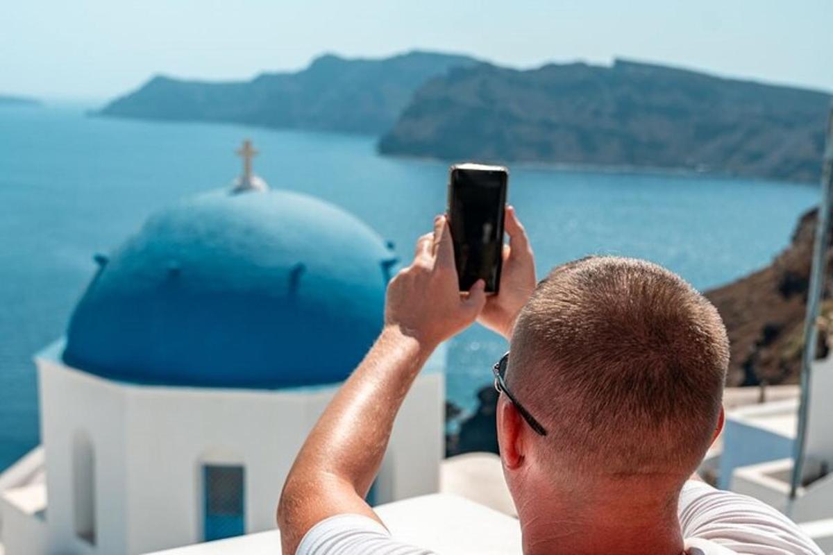muž fotí kostel mobilním telefonem