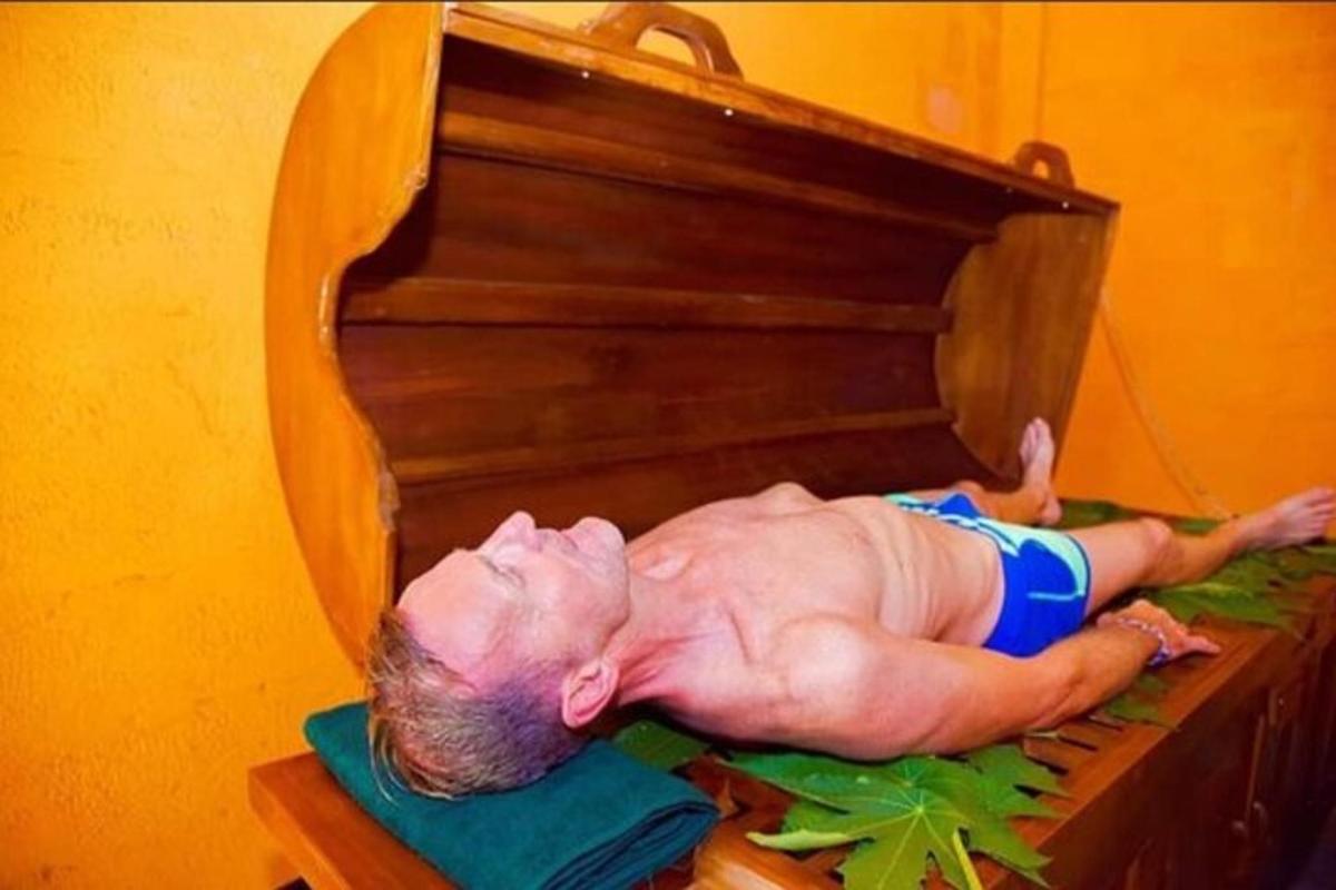 một người đàn ông nằm trên đỉnh một cây đàn piano