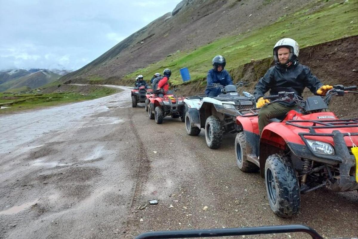 a group of people riding atvs on a dirt road