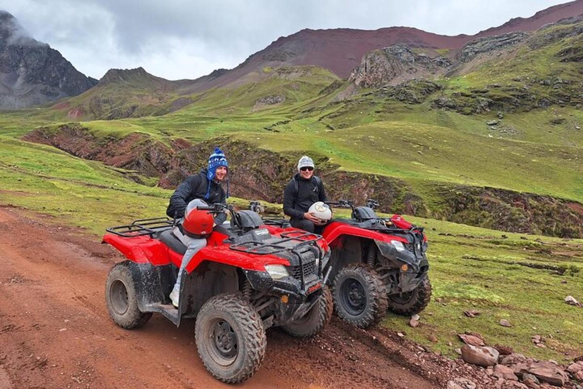 two people sitting on atvs on a dirt road
