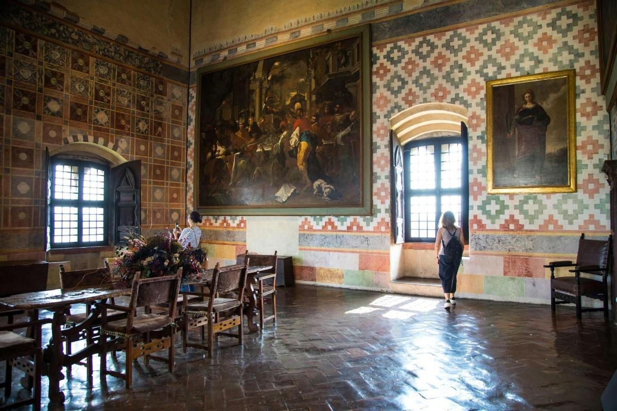 una dona caminant per una sala amb taules i un quadre