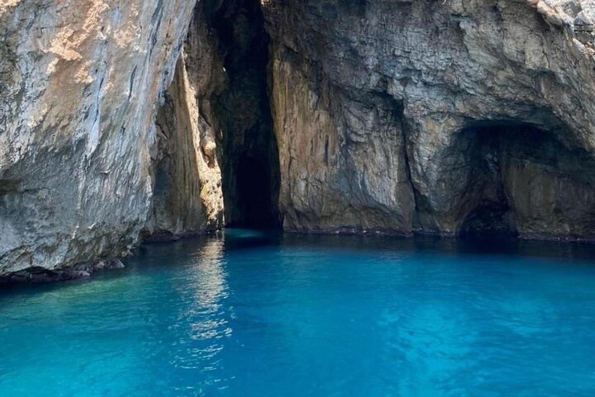 una piscina di acqua blu di fronte a una scogliera