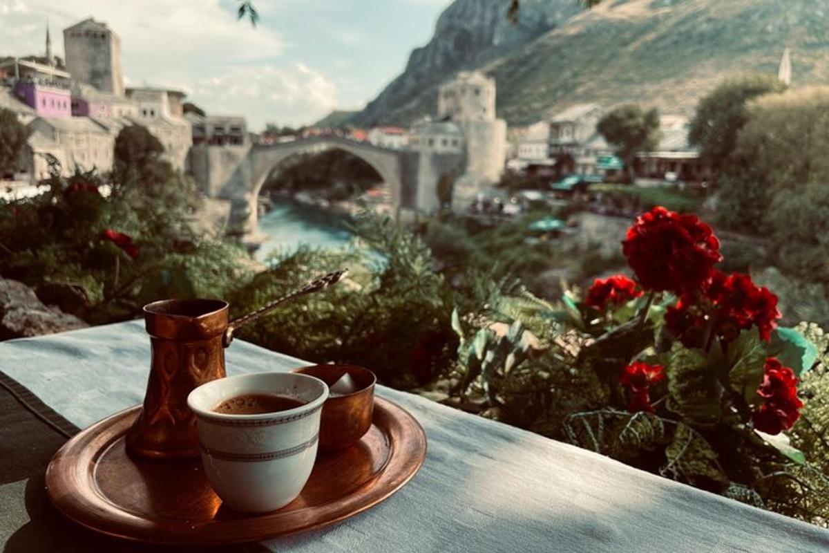 Ένα φλιτζάνι καφέ σε ένα τραπέζι με θέα μια γέφυρα