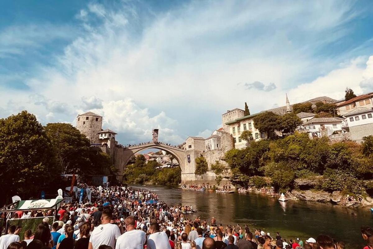 dav ľudí stojacich na rieke s mostom