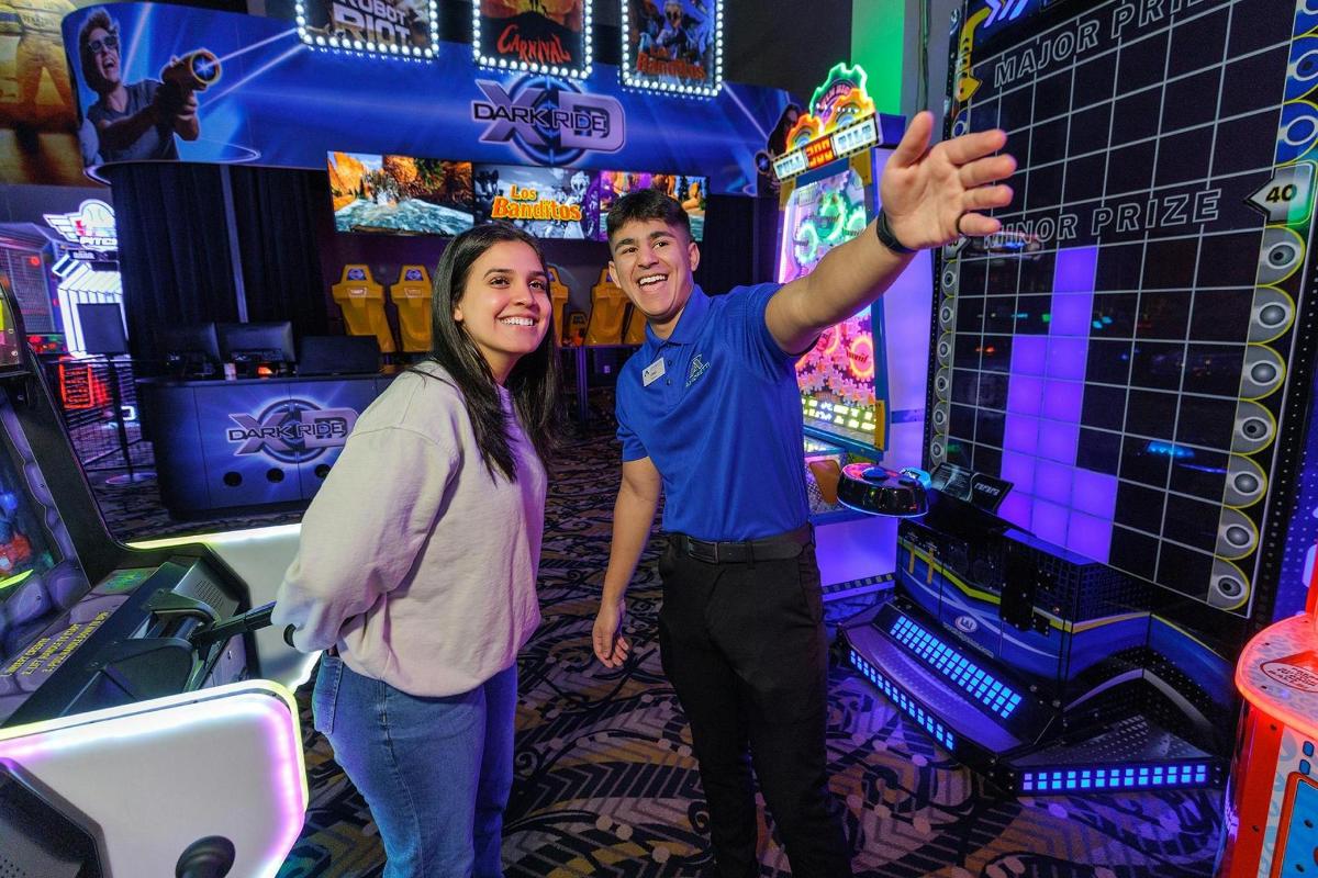 seorang pria dan seorang wanita berdiri di depan video game