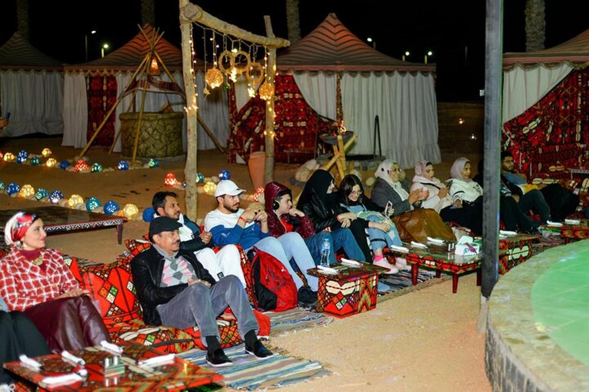 eine Gruppe von Menschen, die in einem Zirkus auf Stühlen sitzen