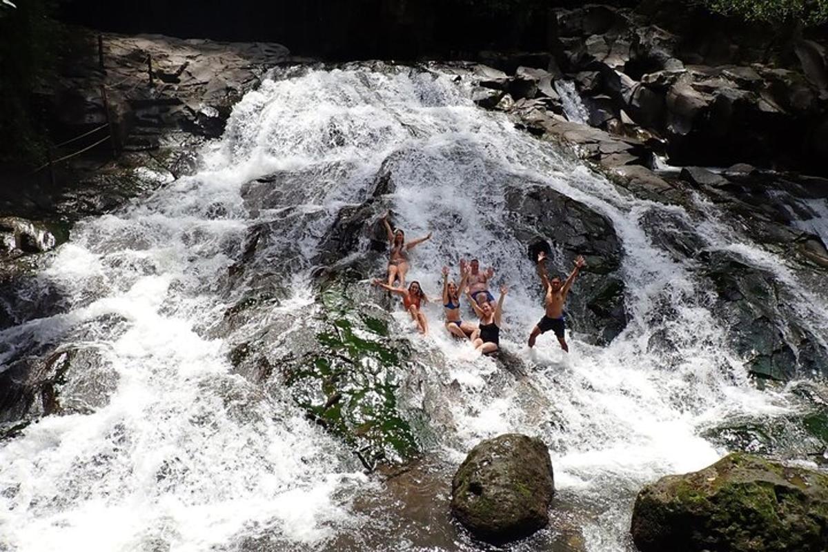 sekumpulan orang melompat di dalam air terjun