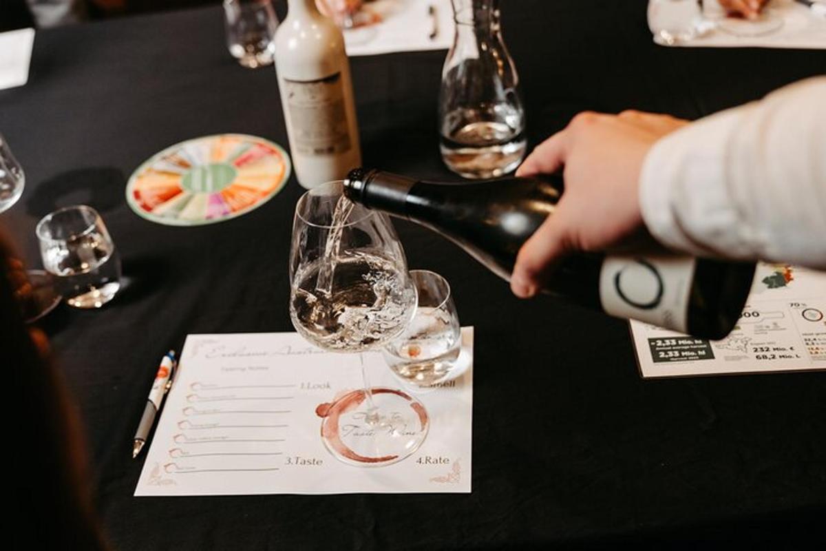 una persona sirviendo una copa de vino en una mesa