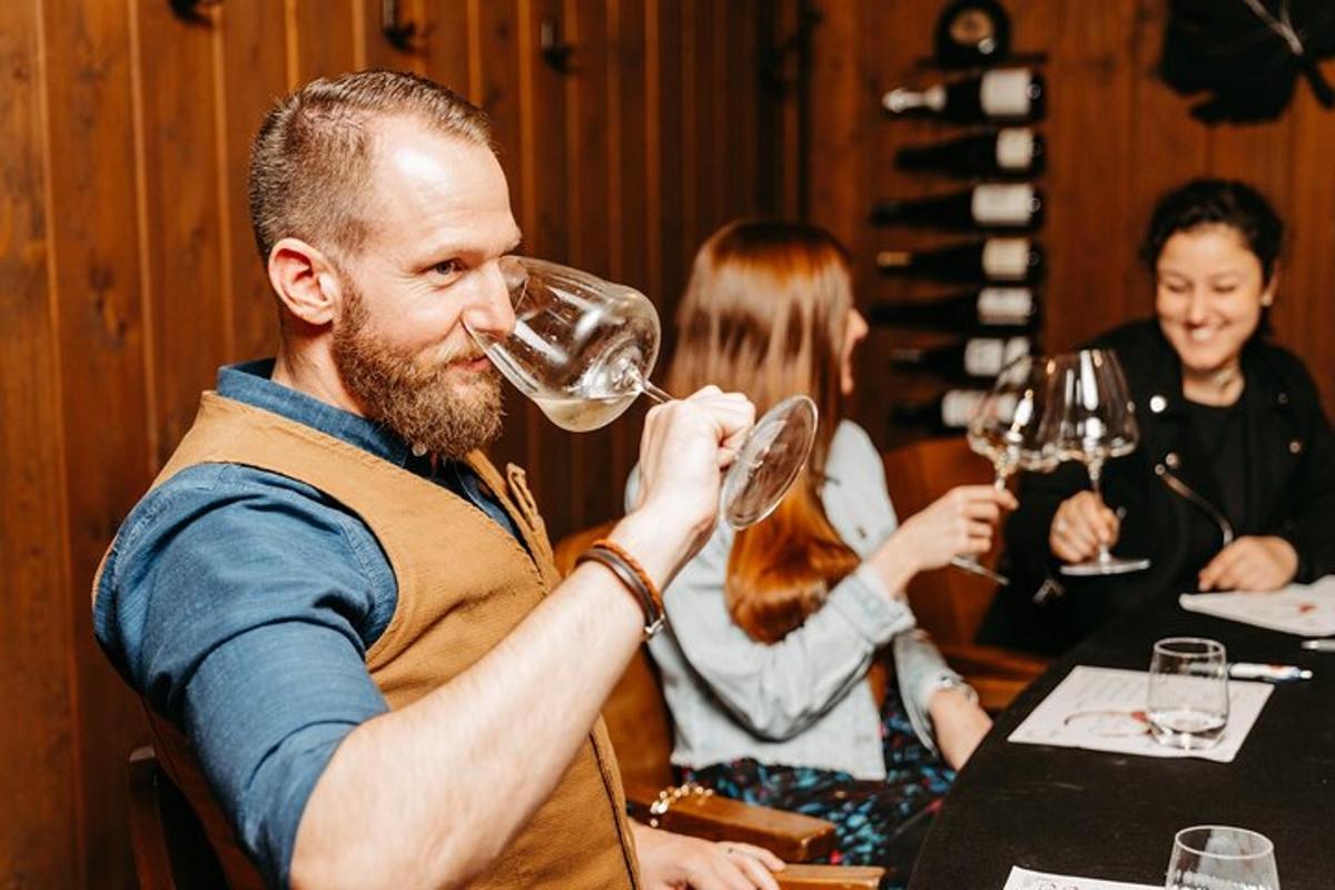 Un hombre bebiendo de una copa de vino en un restaurante.