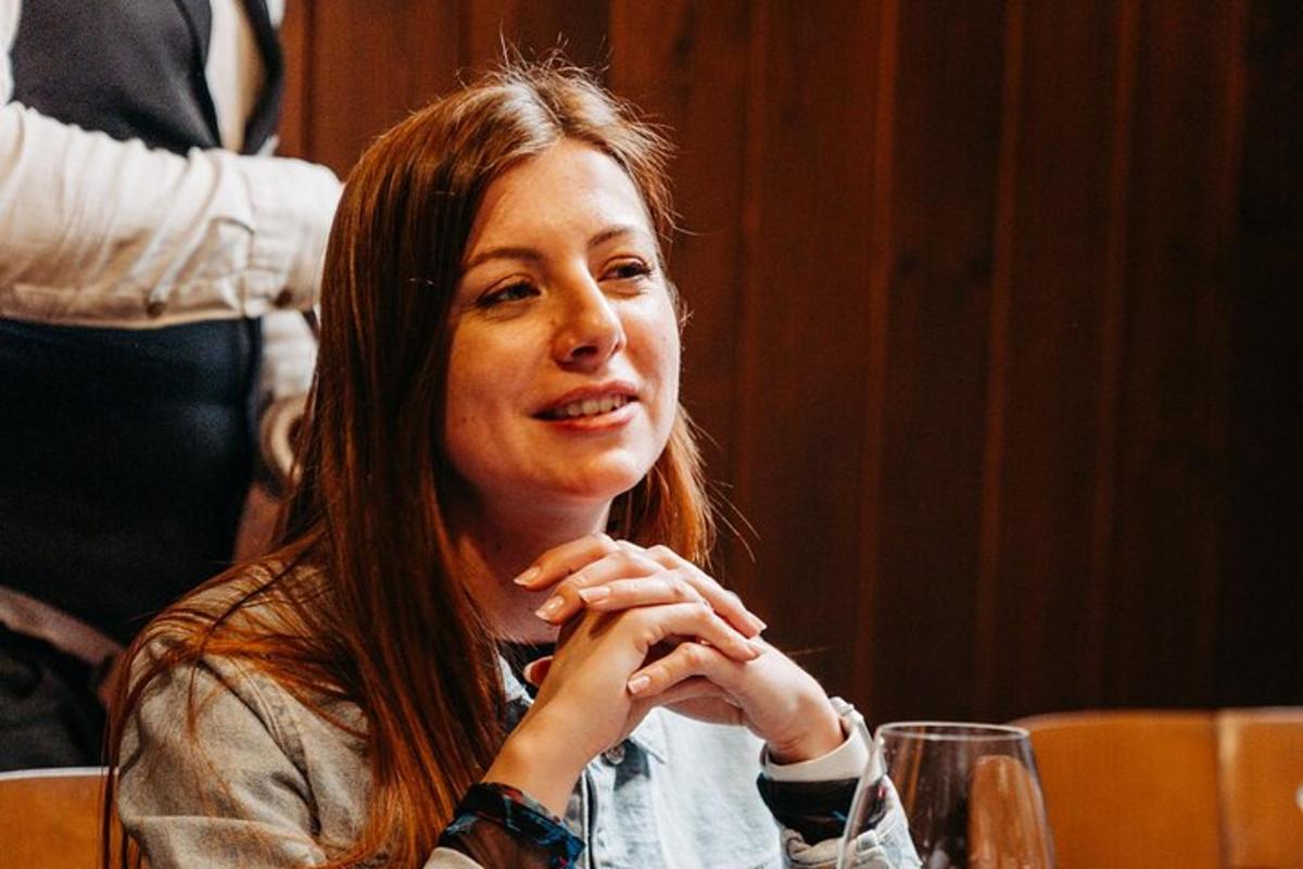 una mujer sentada en una mesa con las manos