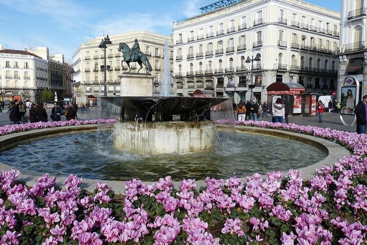 uma fonte no meio de uma cidade com flores rosas