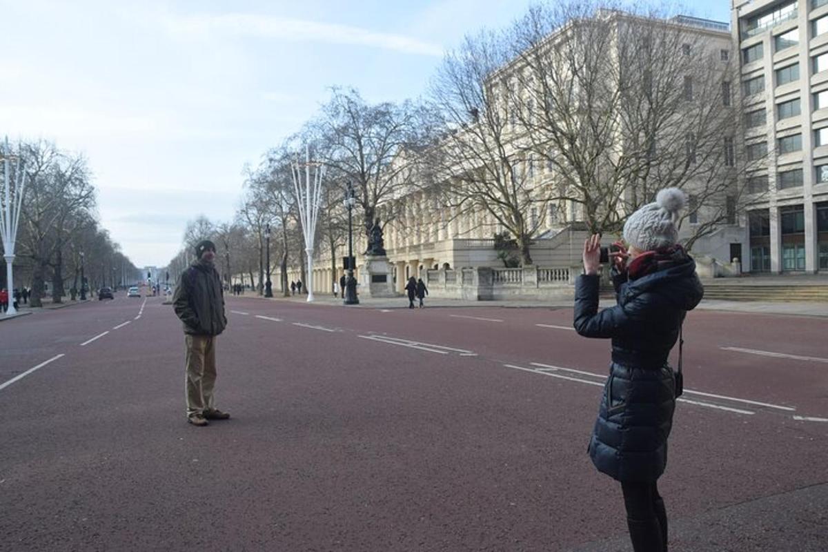 a woman taking a picture of two men standing in the street