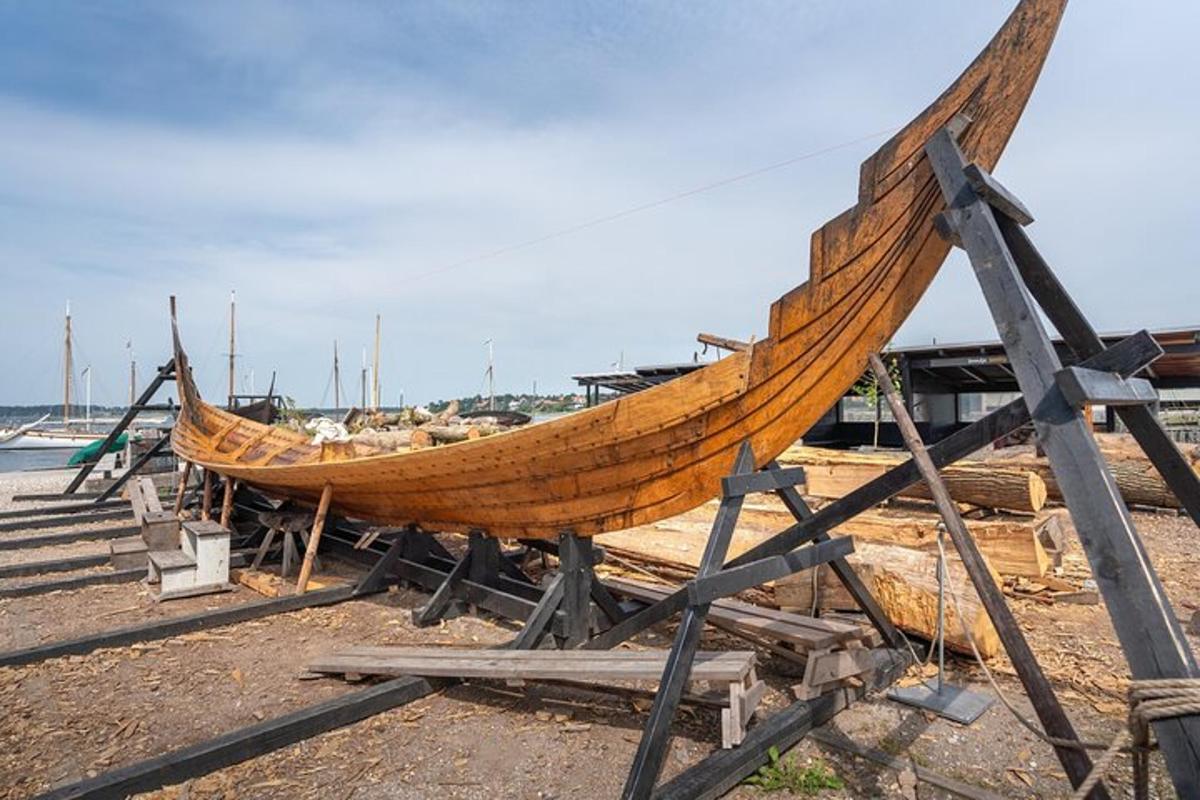 a large wooden boat on display on the beach