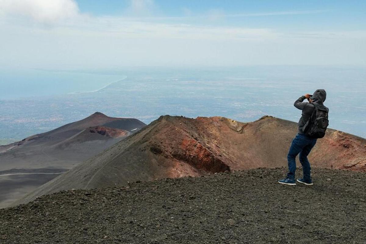 Un hombre parado en la cima de una montaña tomando una fotografía