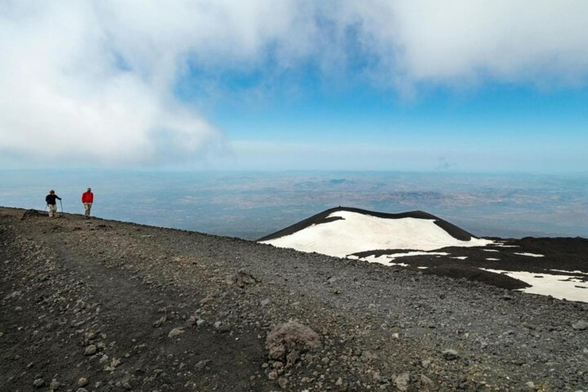 Dos personas de pie en la cima de una montaña cubierta de nieve