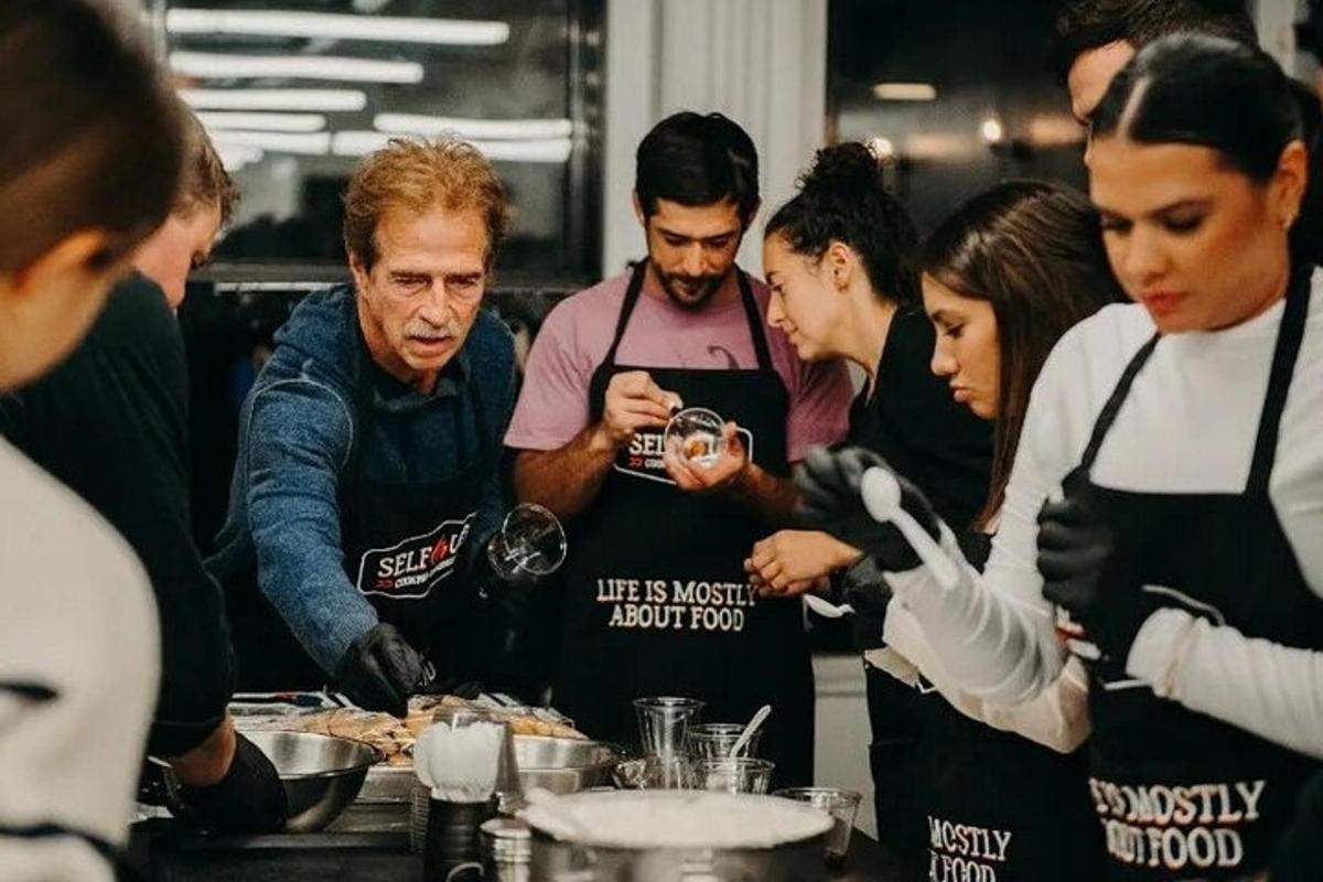 sekumpulan orang berdiri di dapur menyediakan makanan