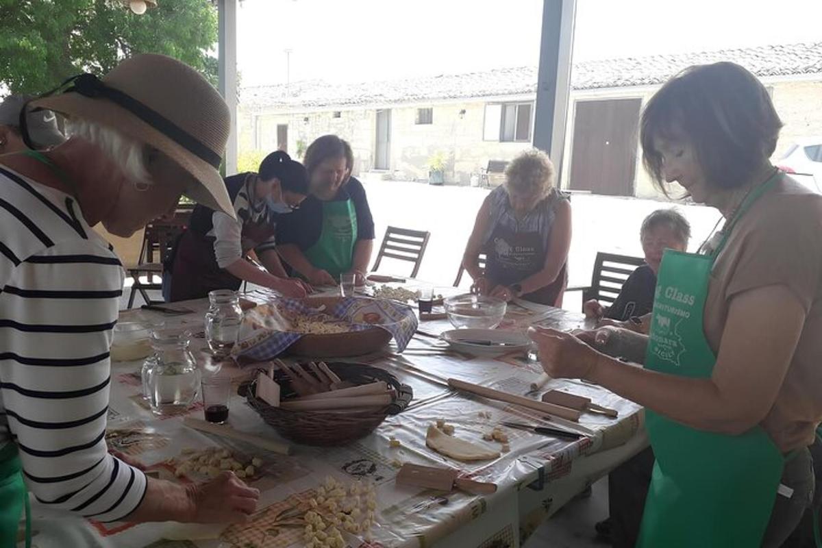 eine Gruppe von Menschen steht mit Essen um einen Tisch herum