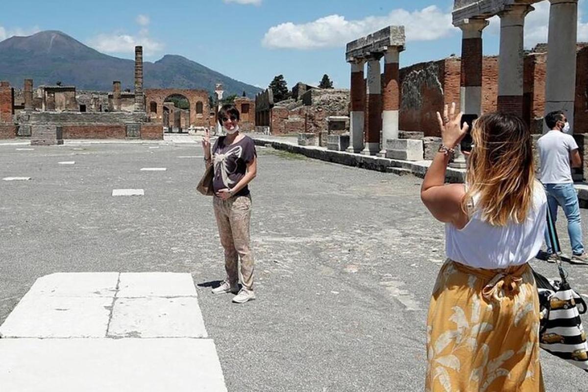 žena fotící muže stojícího na ulici