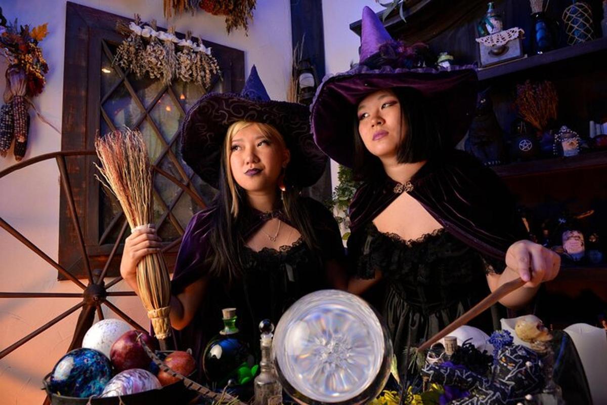 two women dressed in witch costumes standing in a room