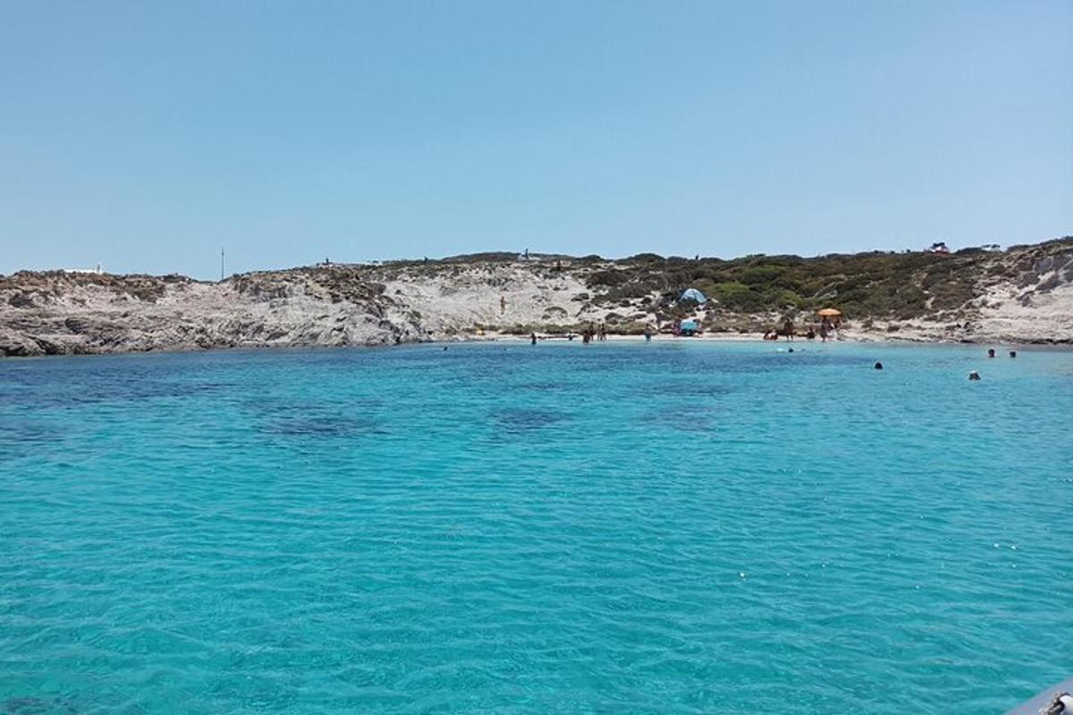 Una playa con agua turquesa y gente en ella.