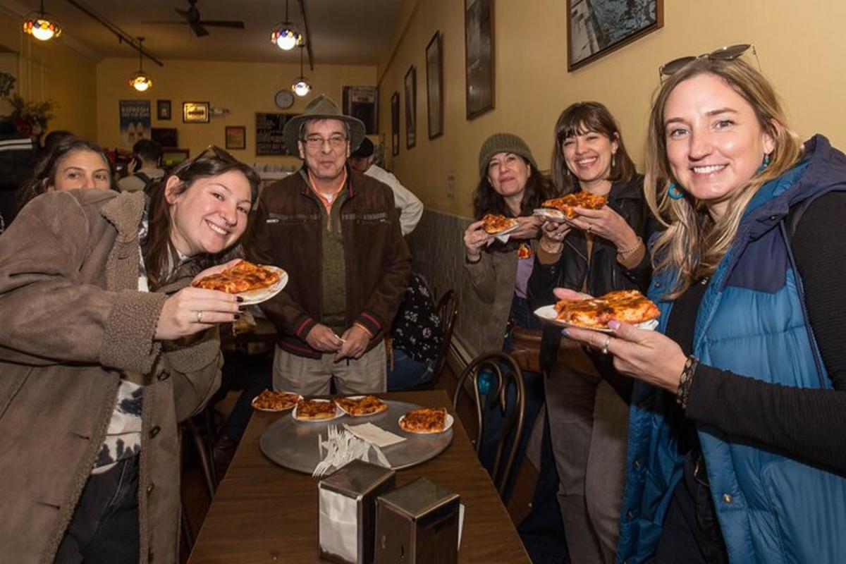 skupina lidí držících talíře s pizzou