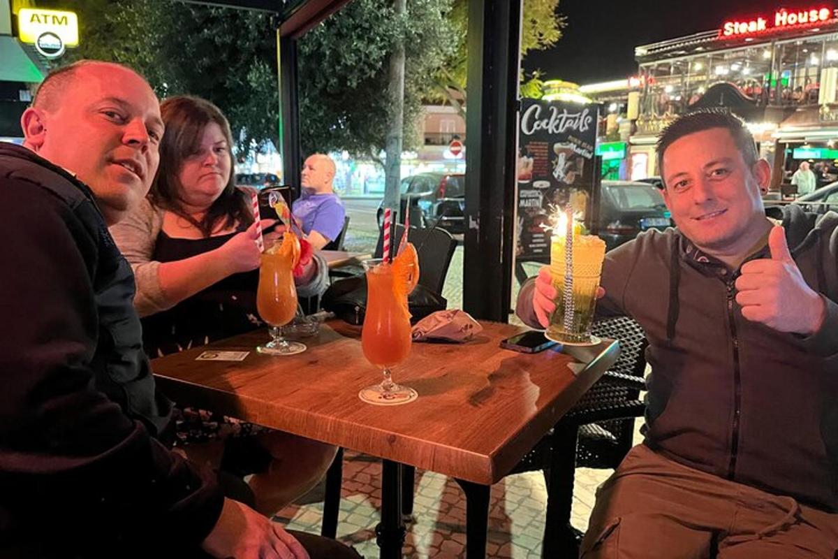 um grupo de pessoas sentadas à mesa com bebidas