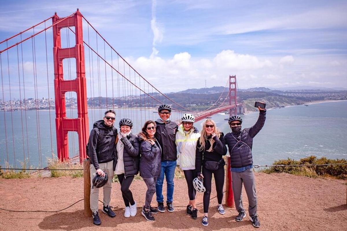a group of people standing in front of the golden gate bridge