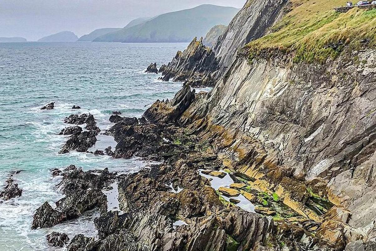 grýtt strandlengja með hafi og fjalli
