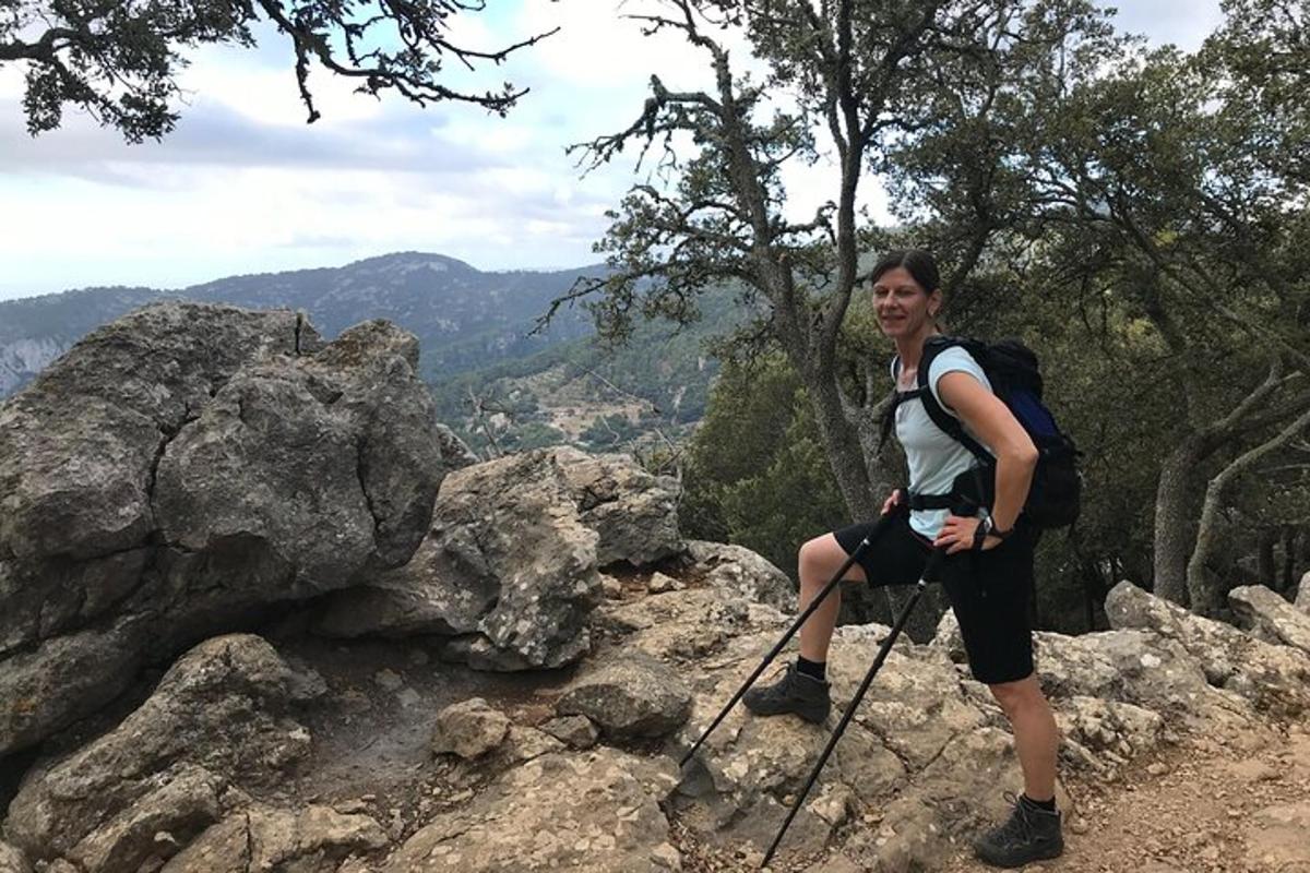 una dona amb una motxilla dempeus al cim d'una muntanya