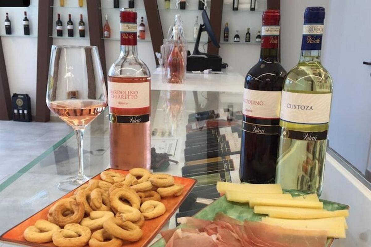 uma mesa de vidro com duas garrafas de vinho e um prato de comida