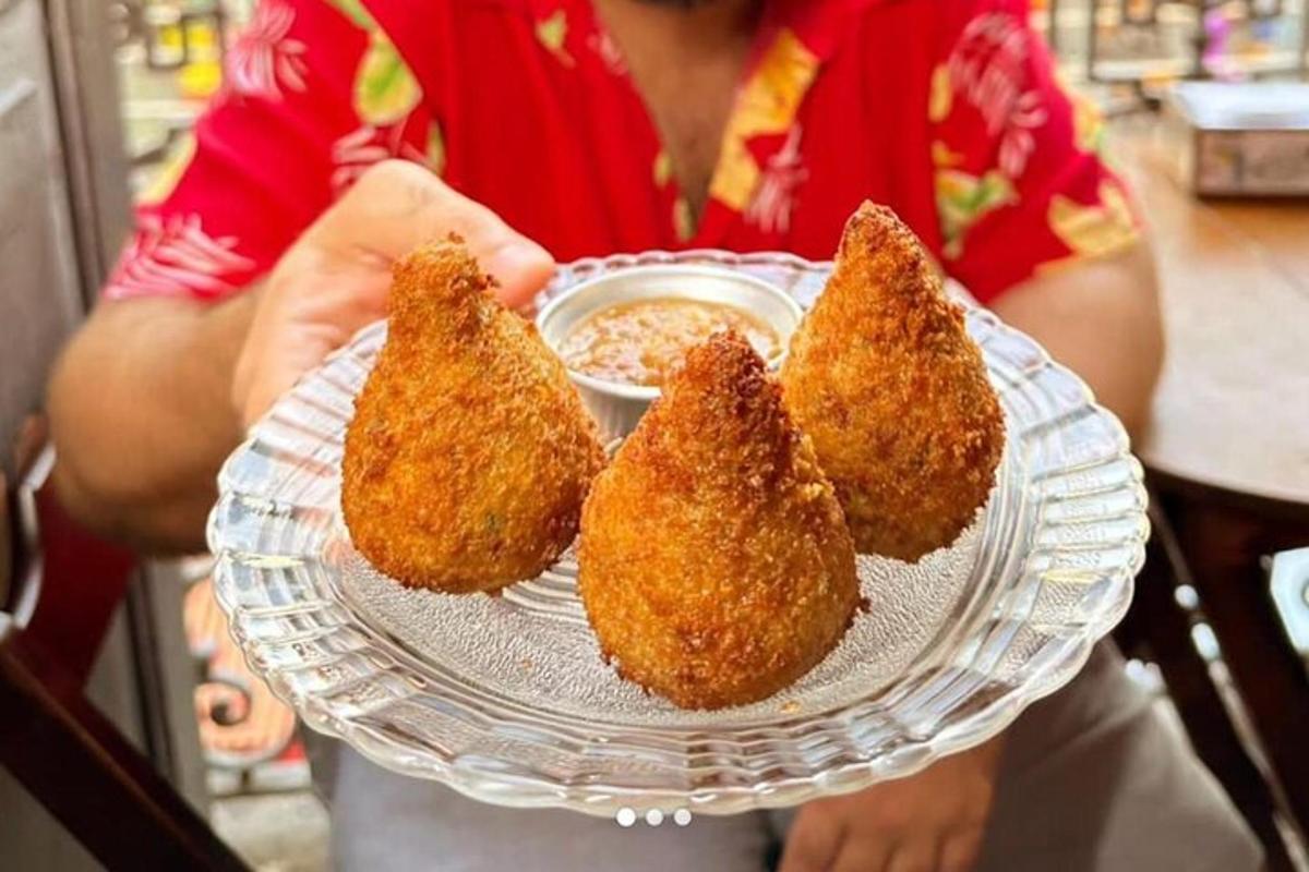 une personne tenant une assiette avec trois wontons frits