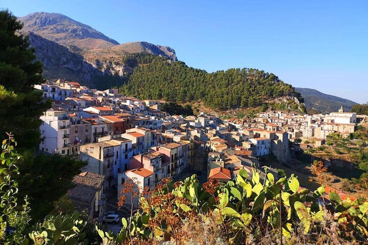 a town on a hill with mountains in the background