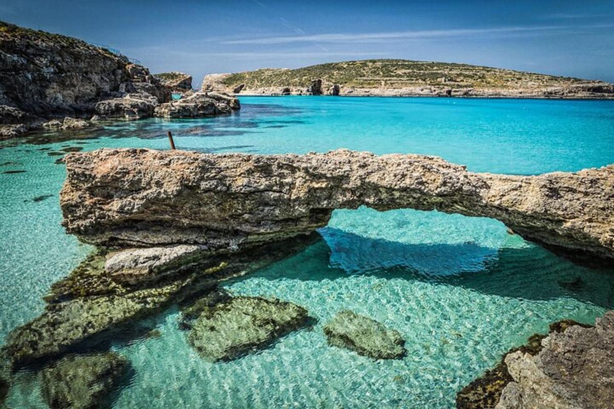 a body of water with rocks and blue water