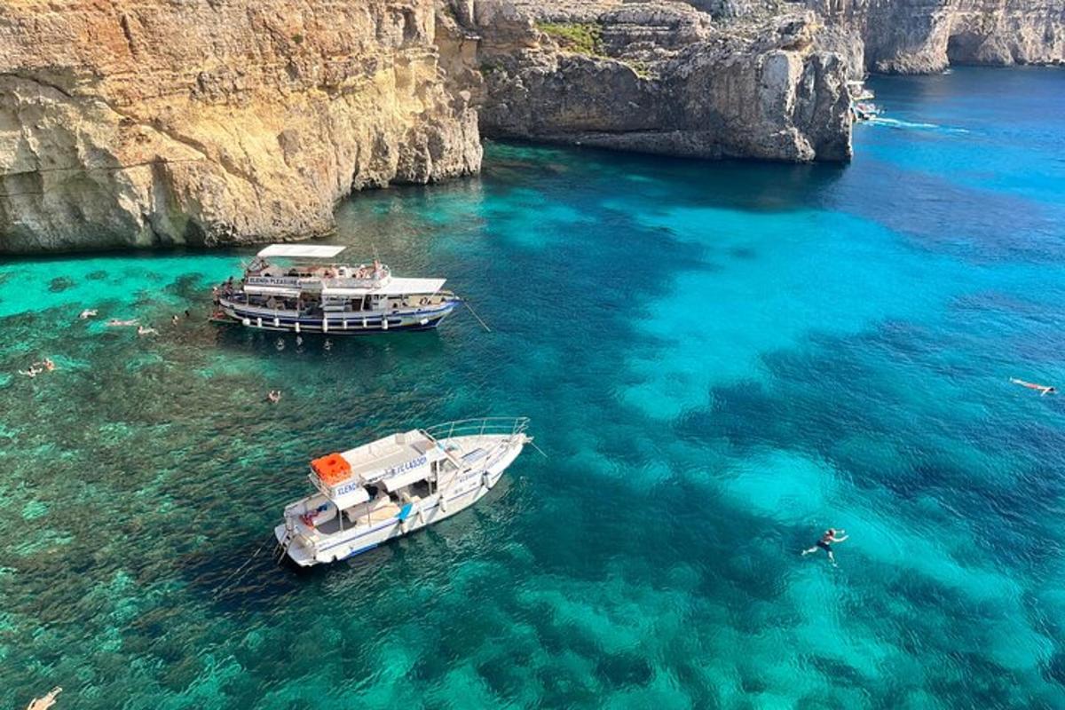 two boats in the water next to a cliff